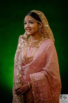 a woman in a pink sari and gold jewelry