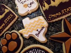 decorated cookies are arranged on a granite countertop for graduation party guests to sign in