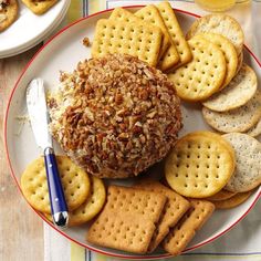 a plate with crackers and cheese ball on it