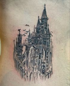 a tattoo on the back of a woman's stomach with an image of a castle