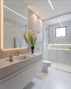 a white bathroom with two sinks and a toilet