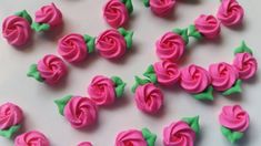 pink frosted roses with green leaves on a white table top, ready to be cut into small pieces