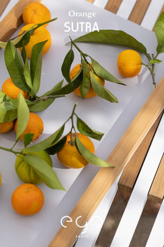 some oranges are sitting on a table with green leaves and the words orange surra