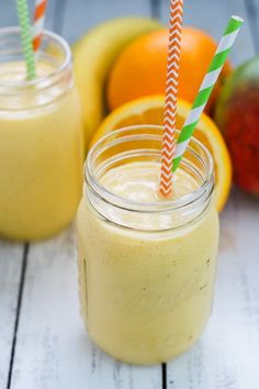 two mason jars filled with smoothies and oranges