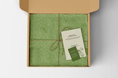 an open box with green wrapping paper on it