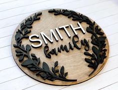 a wooden sign that says smith family with leaves around it and the word's name