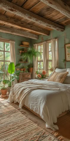 a bed sitting in a bedroom next to two windows with potted plants on them