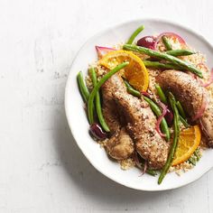 a white plate topped with meat and veggies on top of couscous