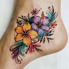 a colorful flower tattoo on the side of a woman's foot with watercolors