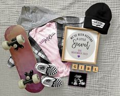 a skateboard, hat, and other items laid out on top of a bed