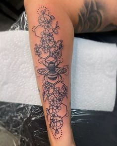 a woman's leg with flowers and a bee on it