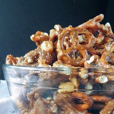 a glass bowl filled with caramel pretzels and nuts