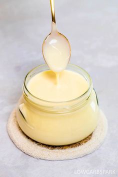 a spoon is pouring liquid into a jar