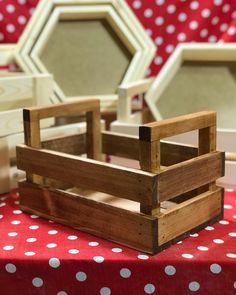 a wooden crate sitting on top of a red and white polka dot covered table cloth