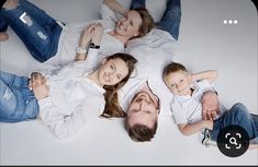 a family laying on the floor with their arms around each other