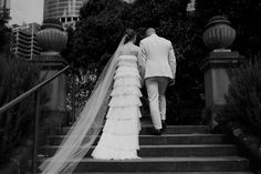 the bride and groom are walking down the stairs