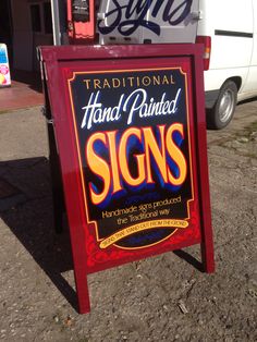 a sign advertising hand painted signs in front of a truck