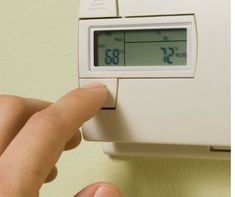 a person pressing the temperature on an air conditioner