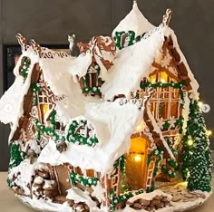 a gingerbread house is decorated with icing and lights