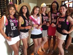 a group of women standing next to each other holding wine glasses