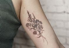 a woman's arm with a flower tattoo on the left side of her arm