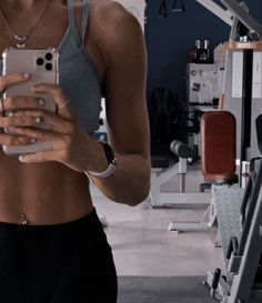 a woman is looking at her cell phone in the gym