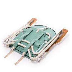 a green and white bag sitting on top of a wooden sled with two handles