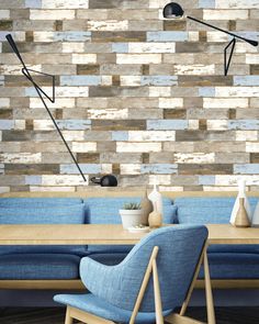 a living room with blue couches and wooden wallpaper on the walls, along with a lamp