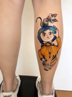 a woman's leg with a cartoon character tattoo on it