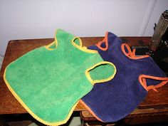 two bibs sitting on top of a wooden table