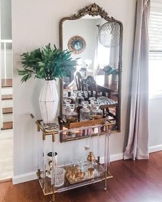 a living room with a mirror, vase and other items on the table in front of it