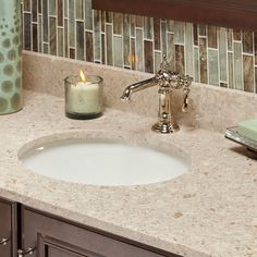 a bathroom sink with a candle on the counter