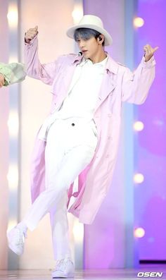 a male in a white suit and hat is dancing