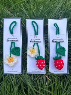 three crocheted strawberries are on display in the grass