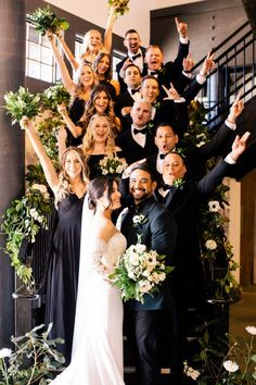 a large group of people standing next to each other in front of a stair case