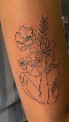 a woman's arm with flowers and leaves on her left side, in black ink