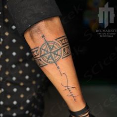 a man with a compass tattoo on his arm and leg is holding a knife in the other hand