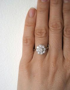 a woman's hand with a diamond ring on it