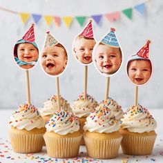 a group of cupcakes with pictures of babies on them sitting in front of some flags