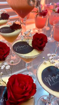 there are many desserts on the table with wine glasses and flowers in them,