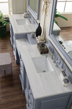 a bathroom vanity with two sinks and mirrors