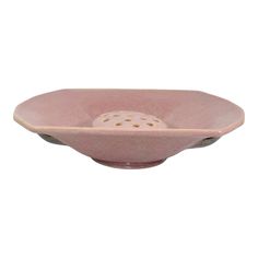 a pink bowl with holes in the center on a white background, it is empty