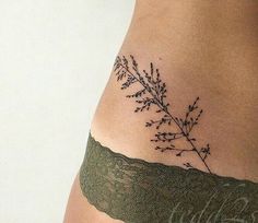 a woman's stomach with a small tattoo on her lower back and the side