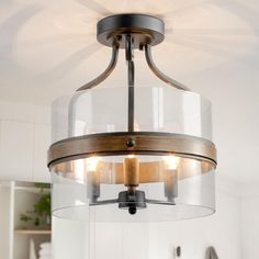 a glass and wood light fixture in a kitchen