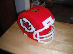 a knitted football helmet sitting on top of a wooden table