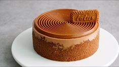 a chocolate cake on a white plate with a cookie in the shape of a spiral