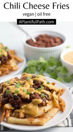 an image of chili cheese fries on a plate with ranch dressing and beans in the background