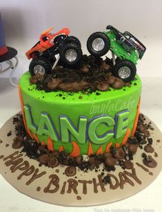 a birthday cake with monster trucks on top