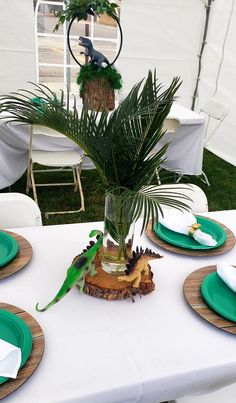 a table set with plates and place settings for two parrots sitting on top of a tree stump