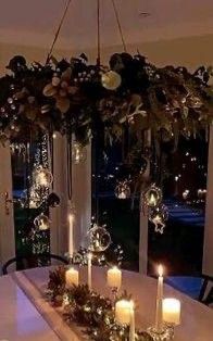 a dining room table with candles and flowers on it, in front of a window